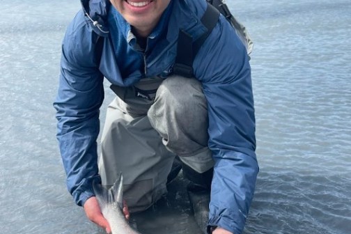 a man holding a fish in the water
