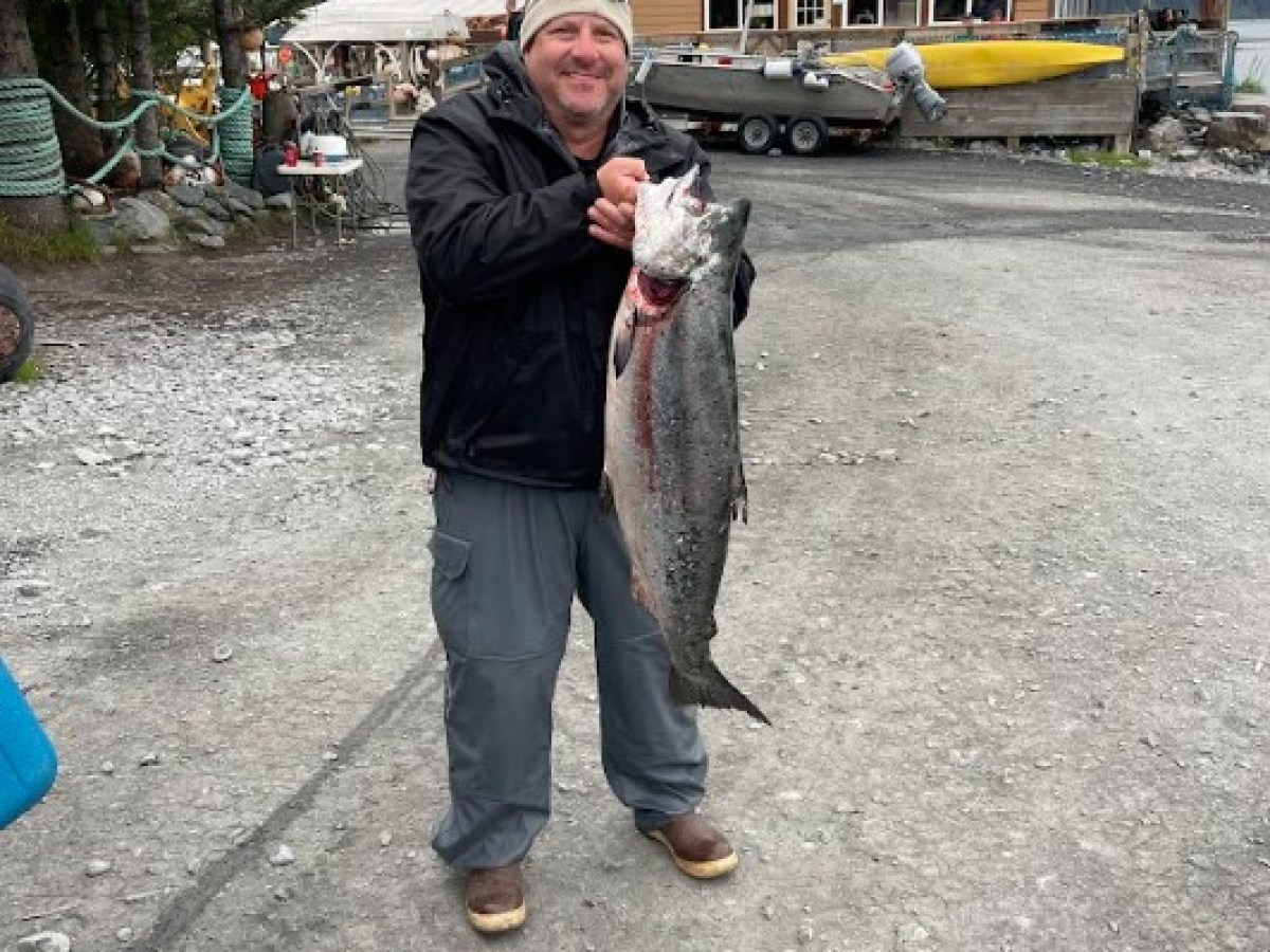 a man holding a King Salmon