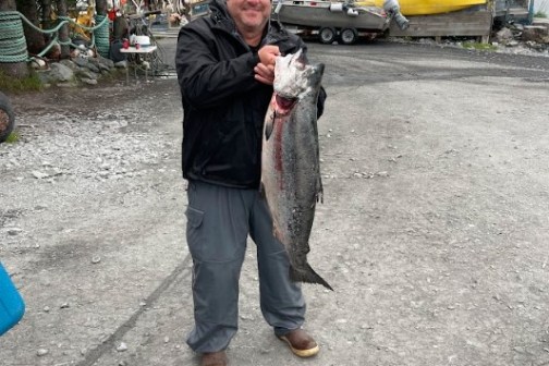 a man holding a King Salmon
