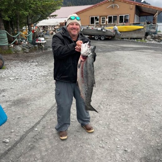a man holding a King Salmon
