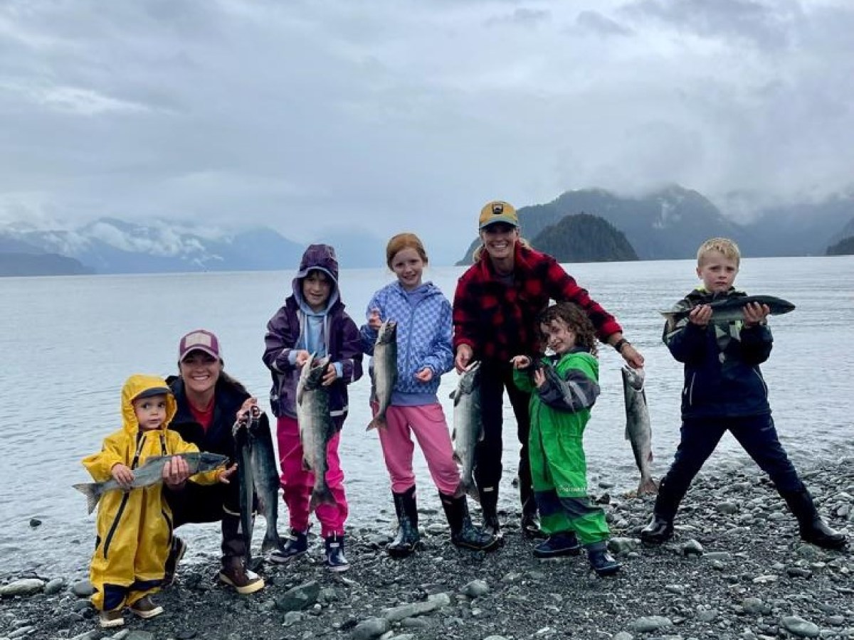 a group of people standing on a rocky beach