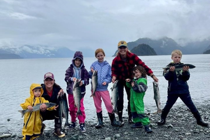 a group of people standing on a rocky beach