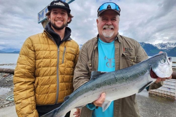 a man holding a fish with the shore fishing guided