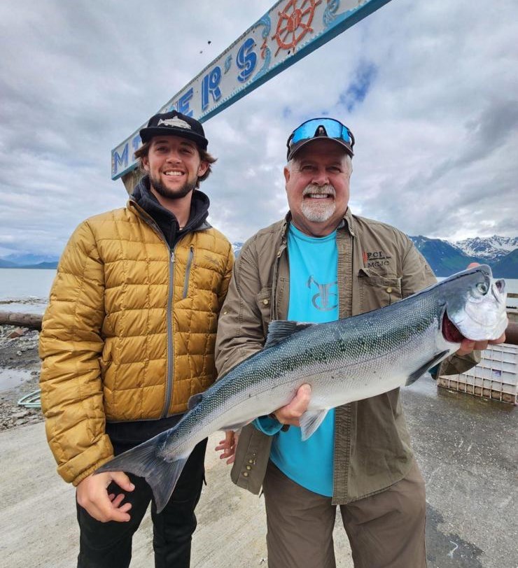 a man holding a fish with the shore fishing guided
