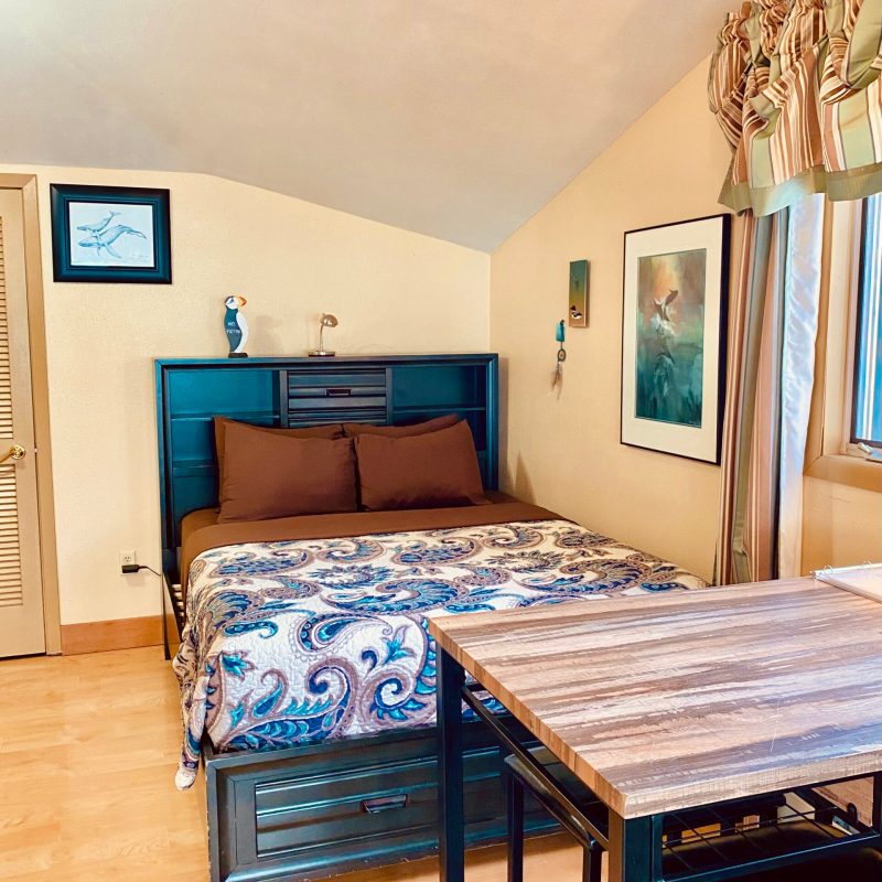 a bedroom with a bed and desk in a room