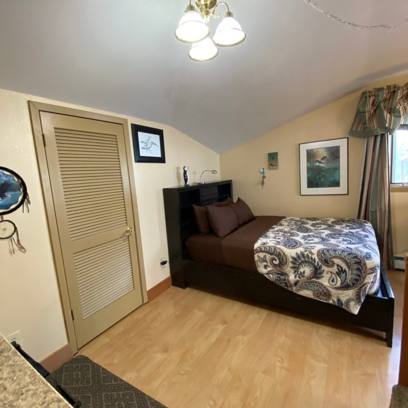 a bedroom with a bed and desk in a small room