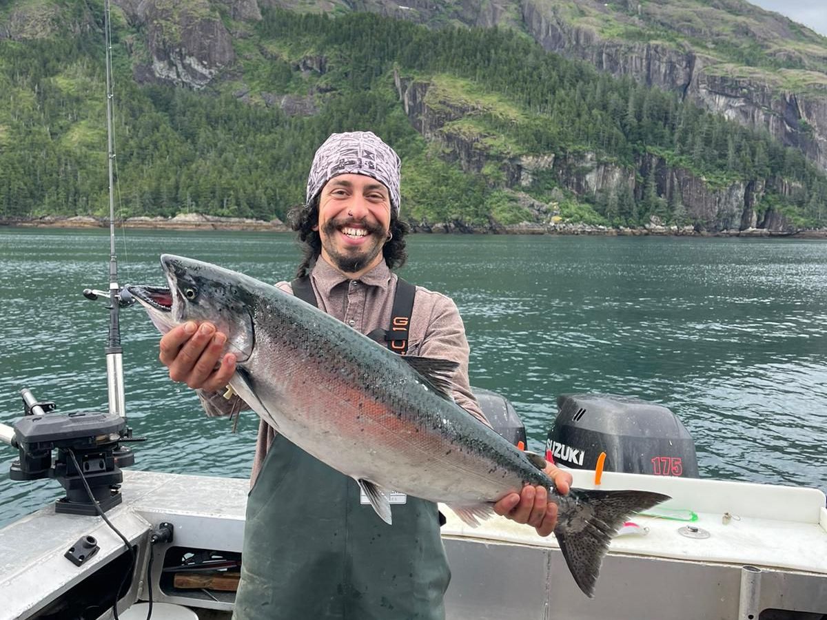 a man holding a fish in the water