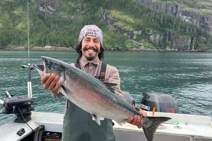 a man holding a fish in the water