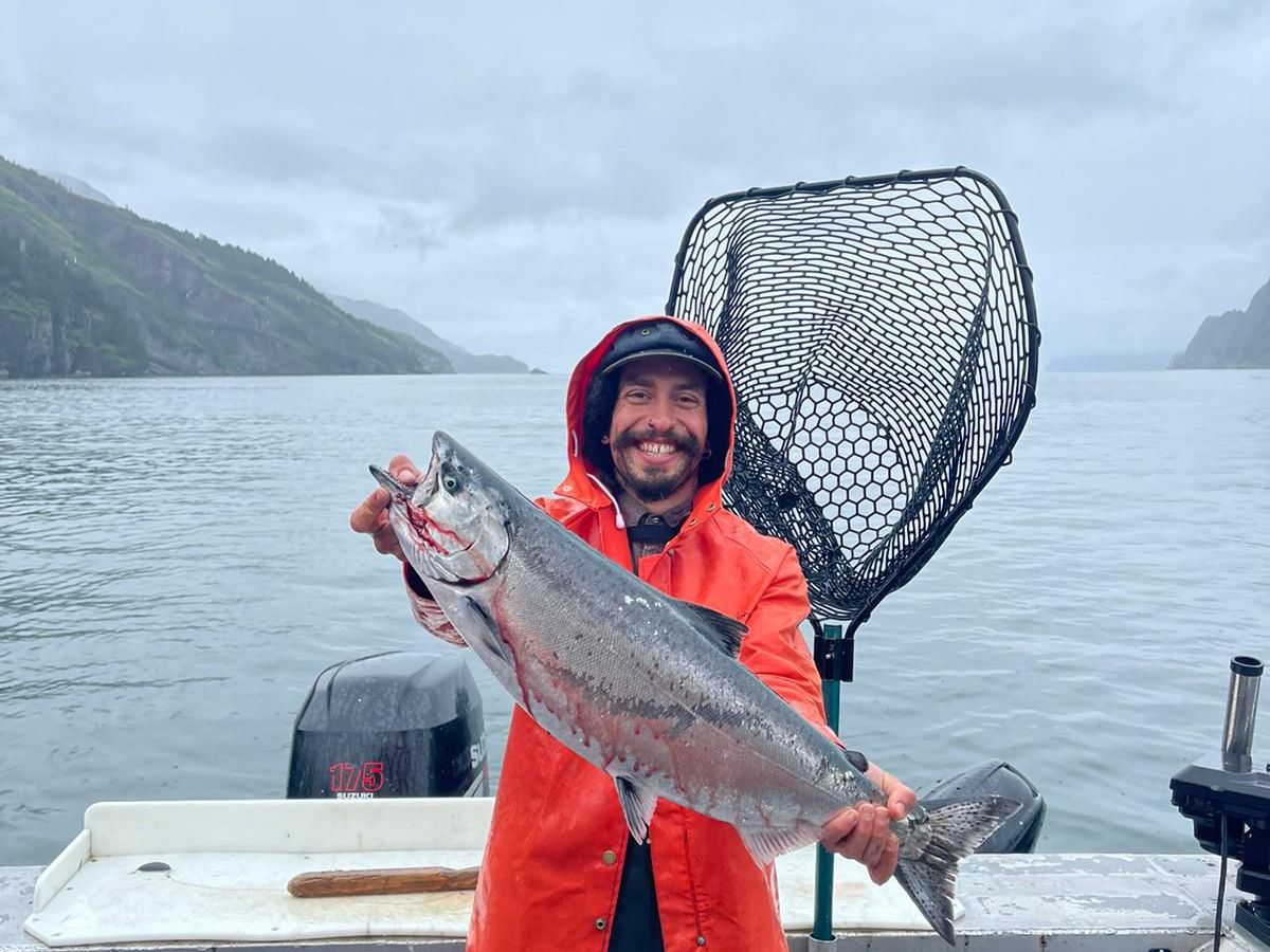a person holding a fish on a boat in a body of water