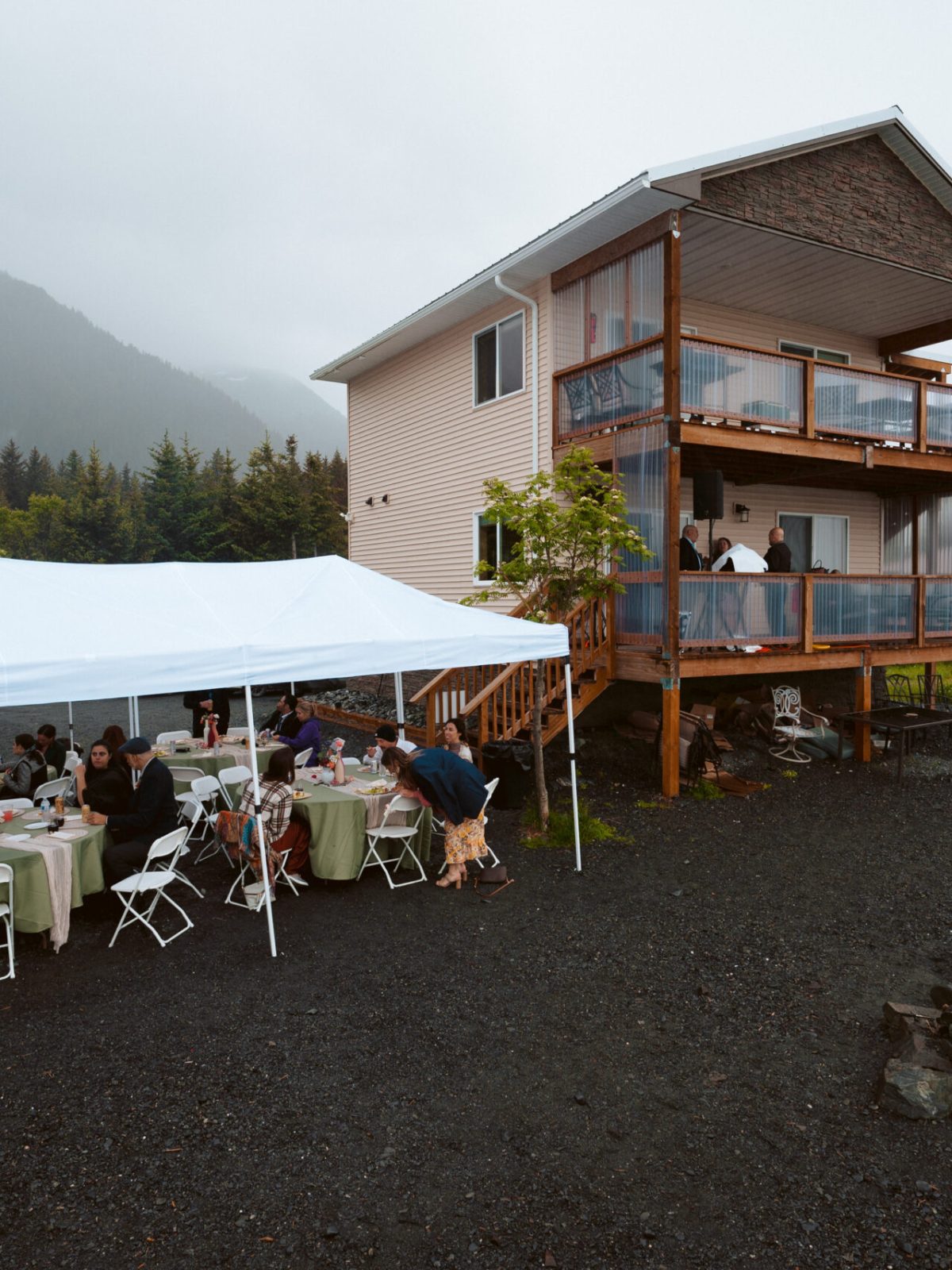 a group of people sitting at a table in front of a house