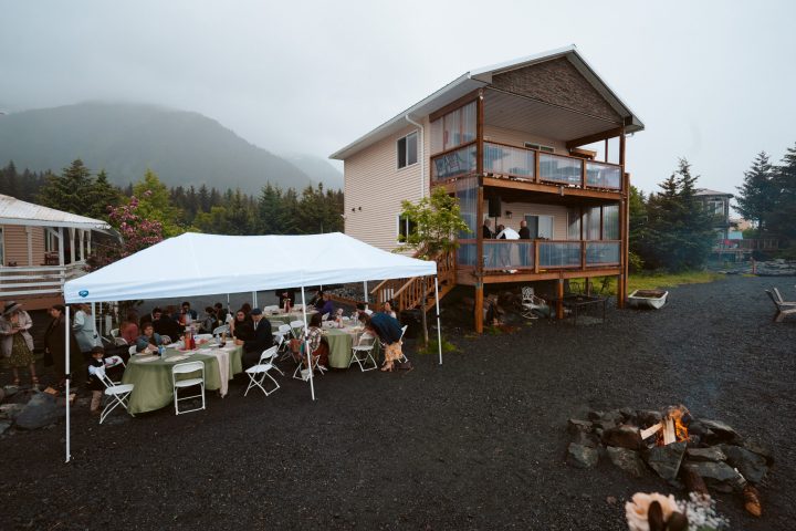 a group of people sitting at a table in front of a house
