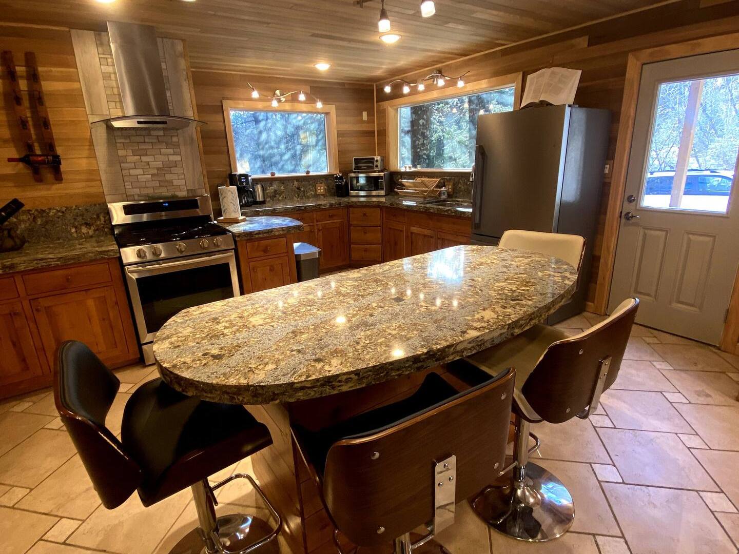 a kitchen with a sitting area and a table with stools