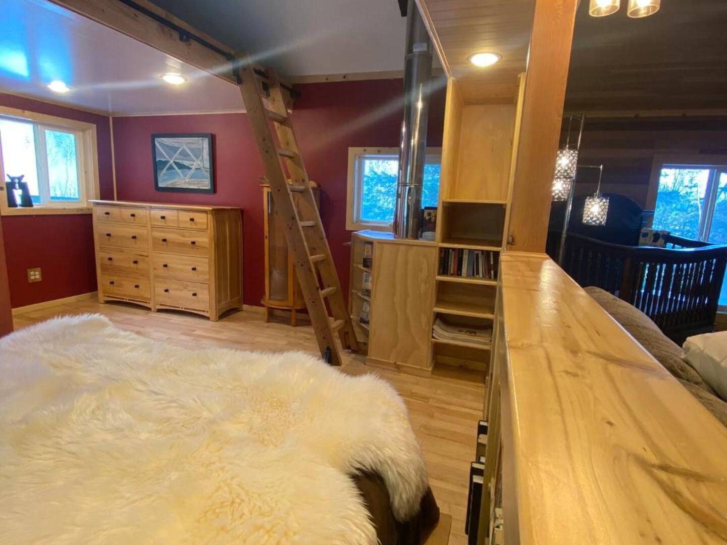 a large room with a ladder and a queen bed