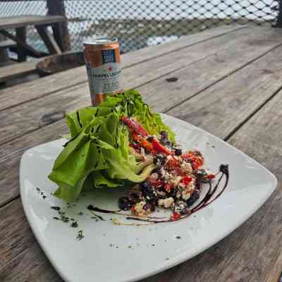 a plate of salad and a glass of beer on a table