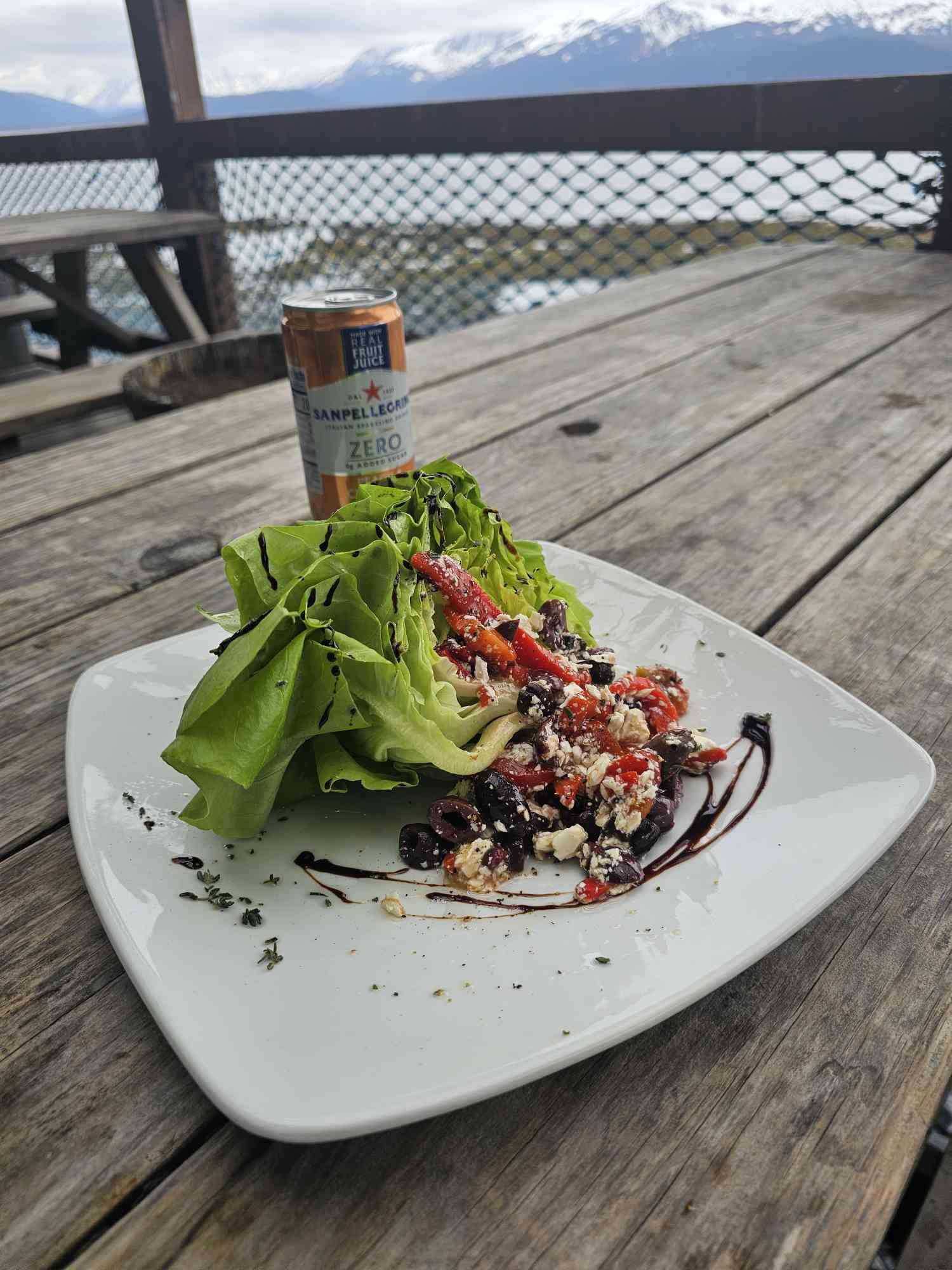 a plate of salad and a glass of beer on a table