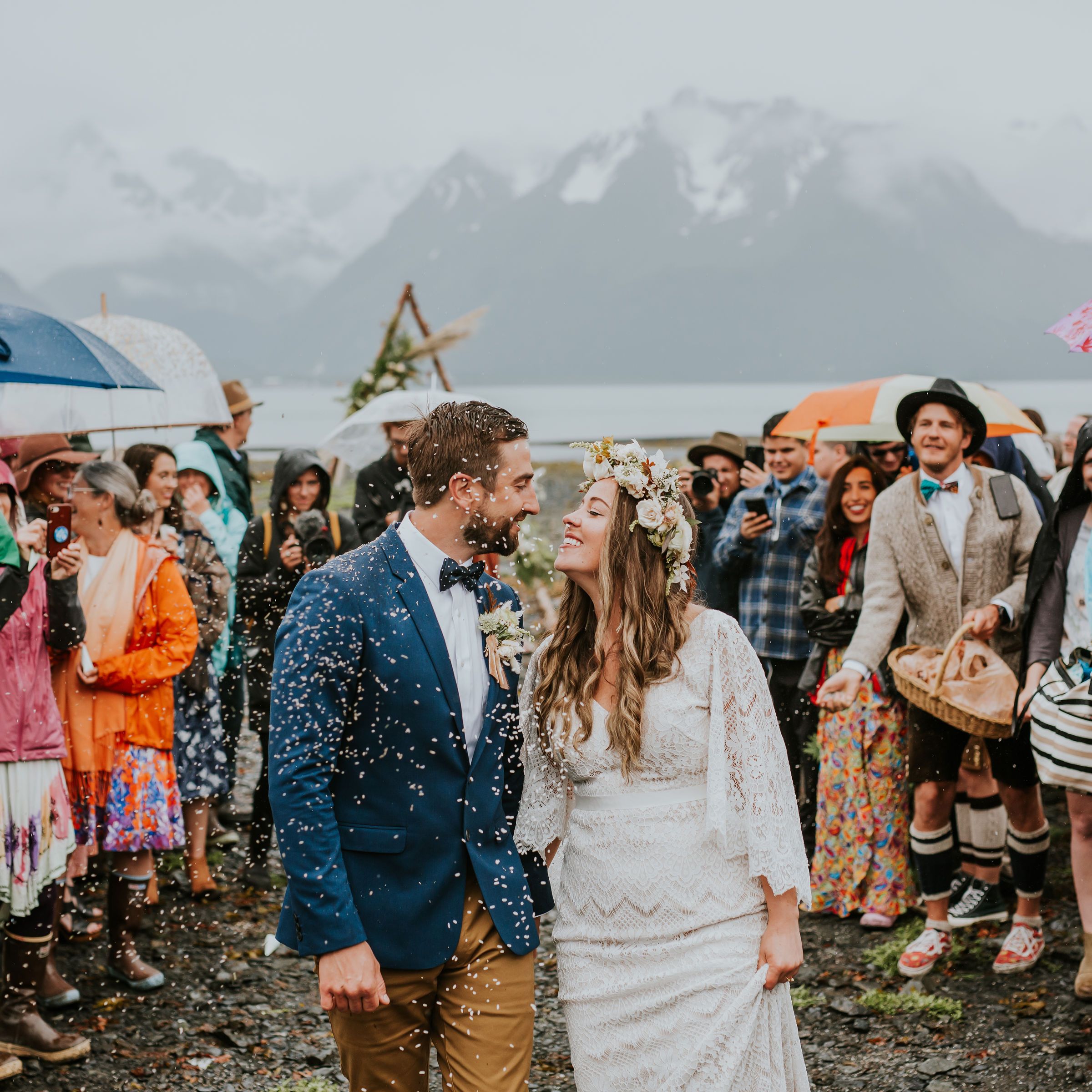 a group of people standing in the rain holding an umbrella