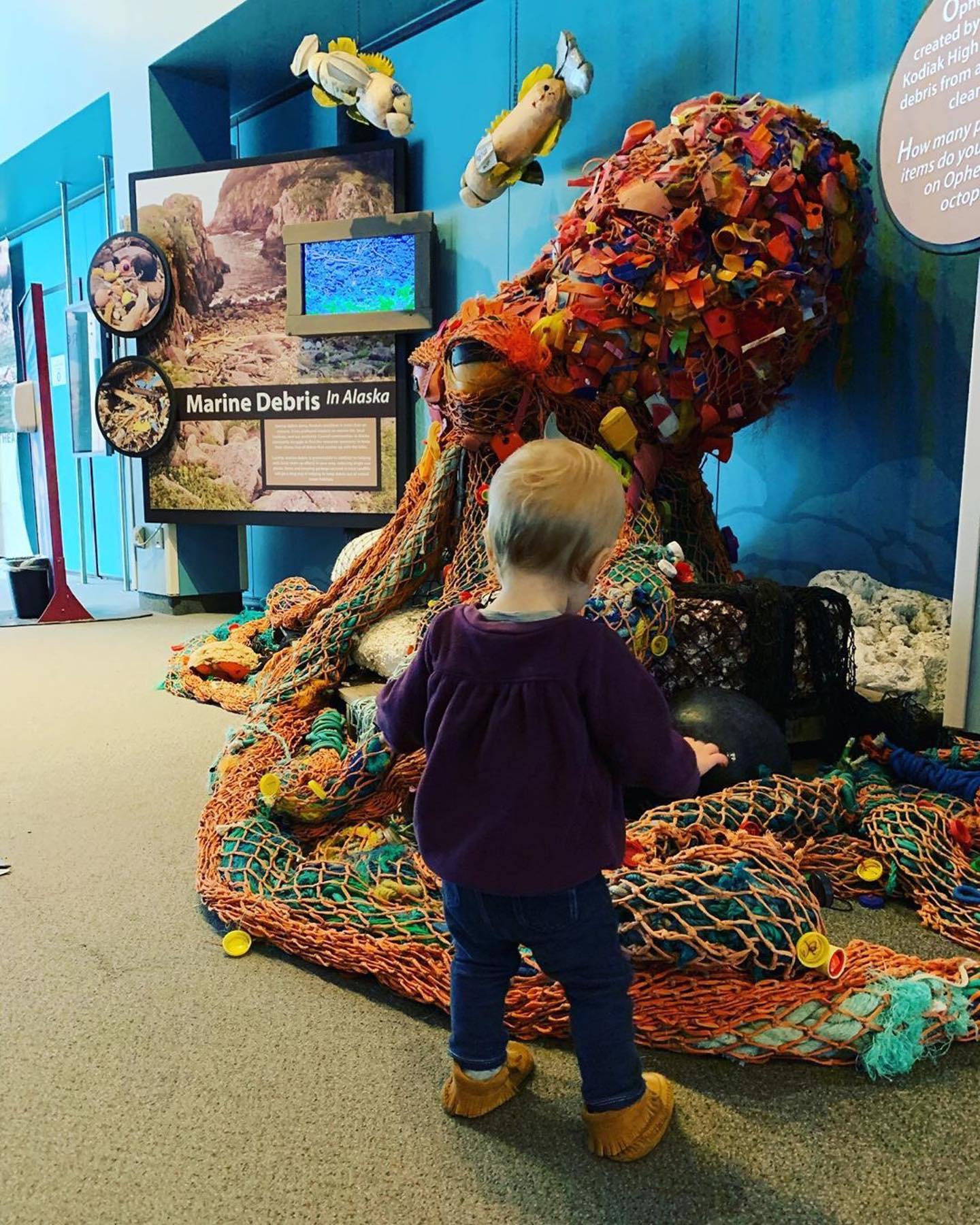 a young boy standing in front of a colorful wall