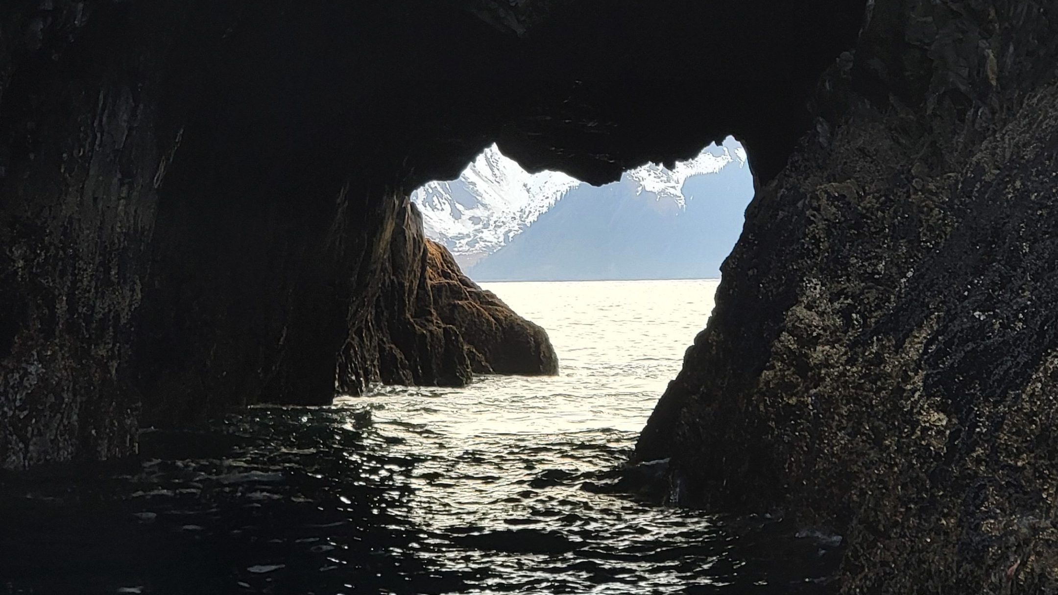 rock opening in a cave of resurrection bay with the mountains in the background
