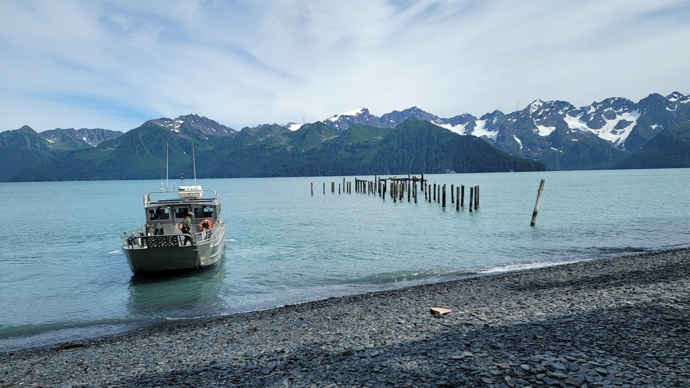 Millers Landing water taxi arriving at North beach in Caines Head with the resurrection bay mountains in the background