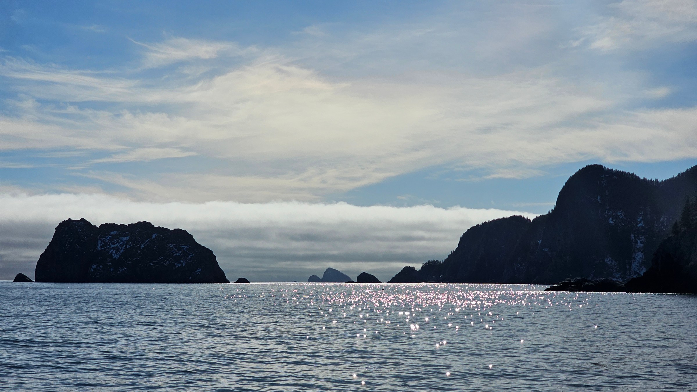 a large body of water with a mountain in the background