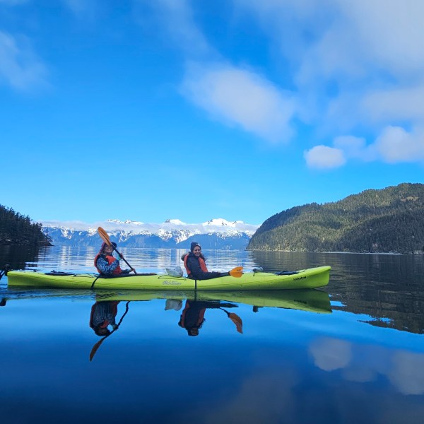 a man riding on the back of a boat in a body of water