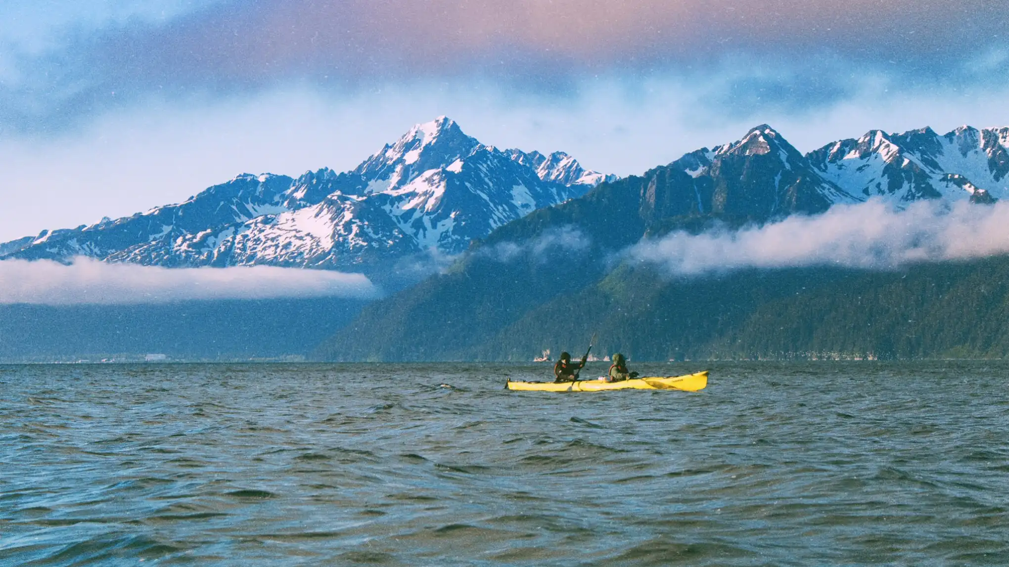a boat on a body of water with a mountain in the background