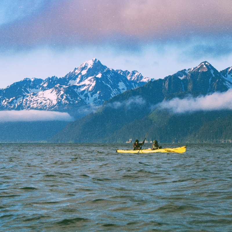 a boat on a body of water with a mountain in the background