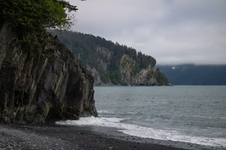 Seward alaska beach Caines heada body of water with a mountain in the background