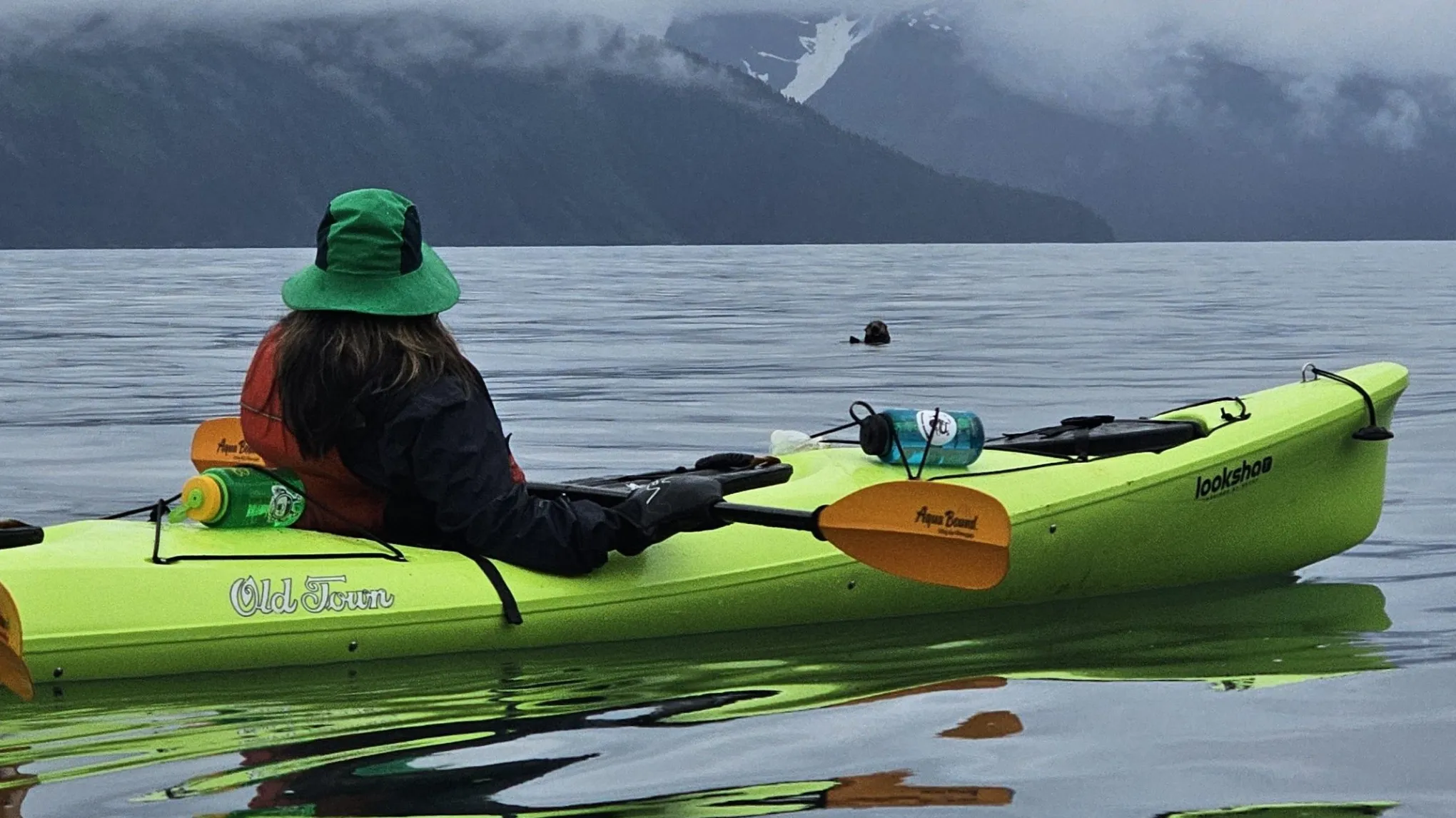 a group of people sitting next to a body of water
