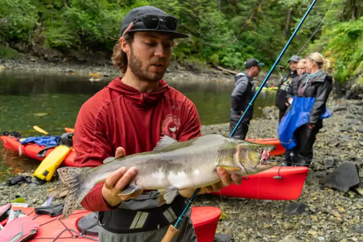 a man holding a fish in the water
