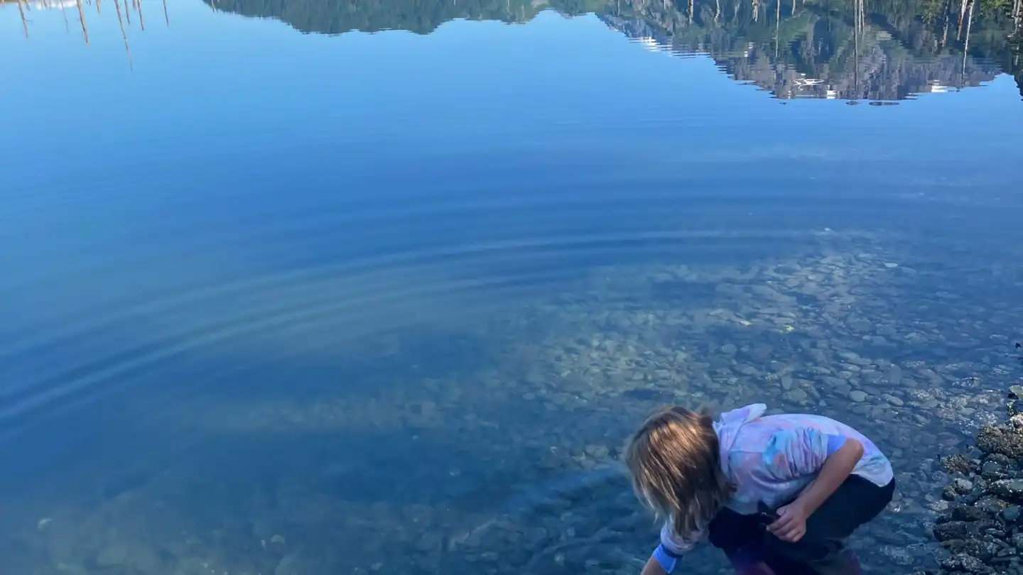 a man standing next to a body of water