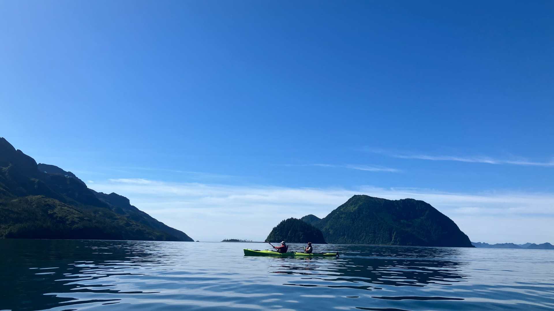 a large body of water with a mountain in the background