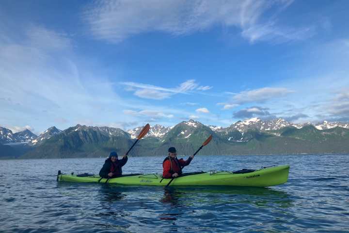 a group of people riding on the back of a boat in the water