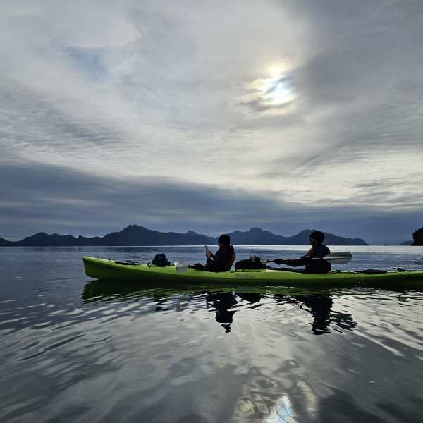 a group of people standing next to a body of water