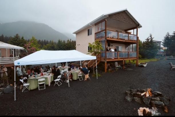 a group of people sitting at a table in front of a house