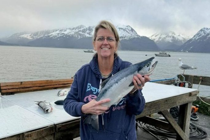a man standing next to a body of water