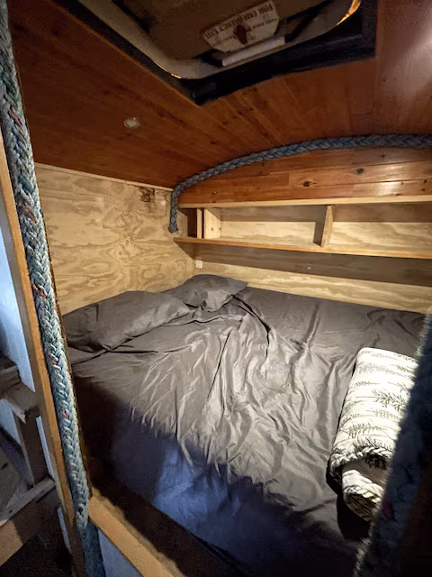 Cozy wooden bunk bed with gray bedding and a folded blanket.